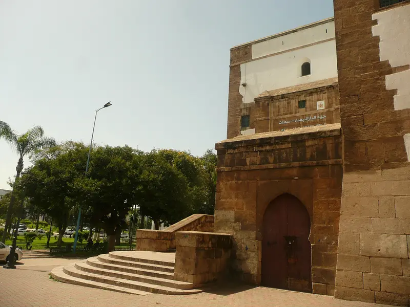 Façade en pierre et porte en arc à un angle de rue de Casablanca